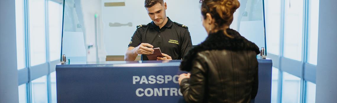 Photo of women having passport checked by customs officer